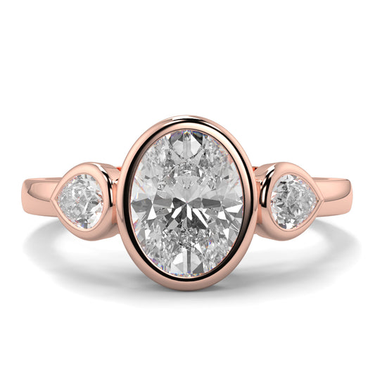 Rose gold ring with three diamonds on a white background oval and pear diamond trilogy ring yb jewellers best selling design and engagement rings 
