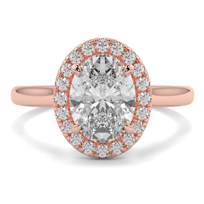 Rose gold ring with a large diamond and smaller diamonds around on a white background yb jewellers iamond halo with plain shoulder oval shape 