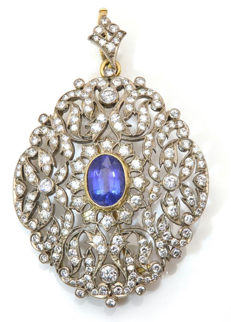 Ornate pendant with blue gemstone and diamond accents on a white background