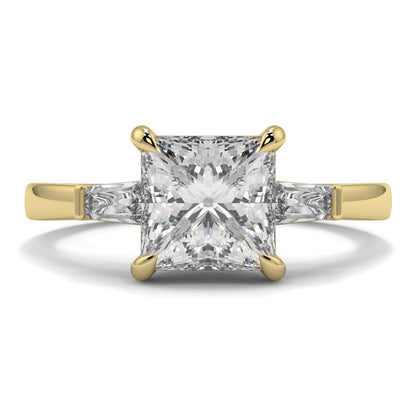 Gold ring with a large diamond on a white background yb_jewellers_3_stone_trilogy_engagement_ring_round_and_pear_shape_best_selling_design_trending_diamond_ring