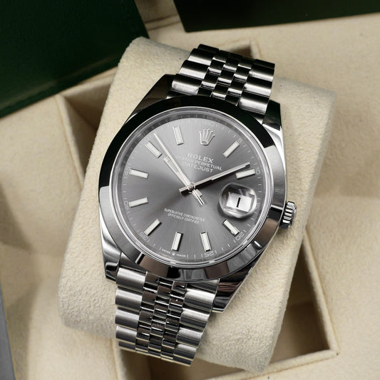 Silver Rolex watch with a gray face on beige fabric