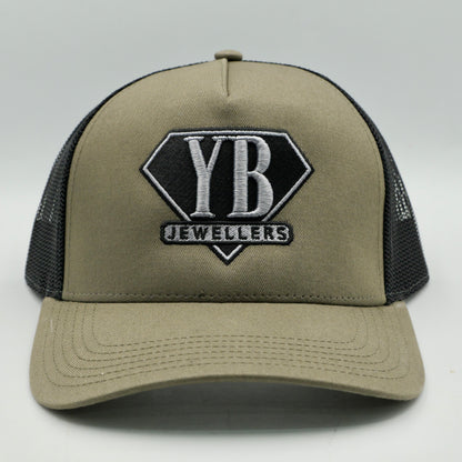 Beige trucker cap with black mesh and YB Jewellers logo on a white background