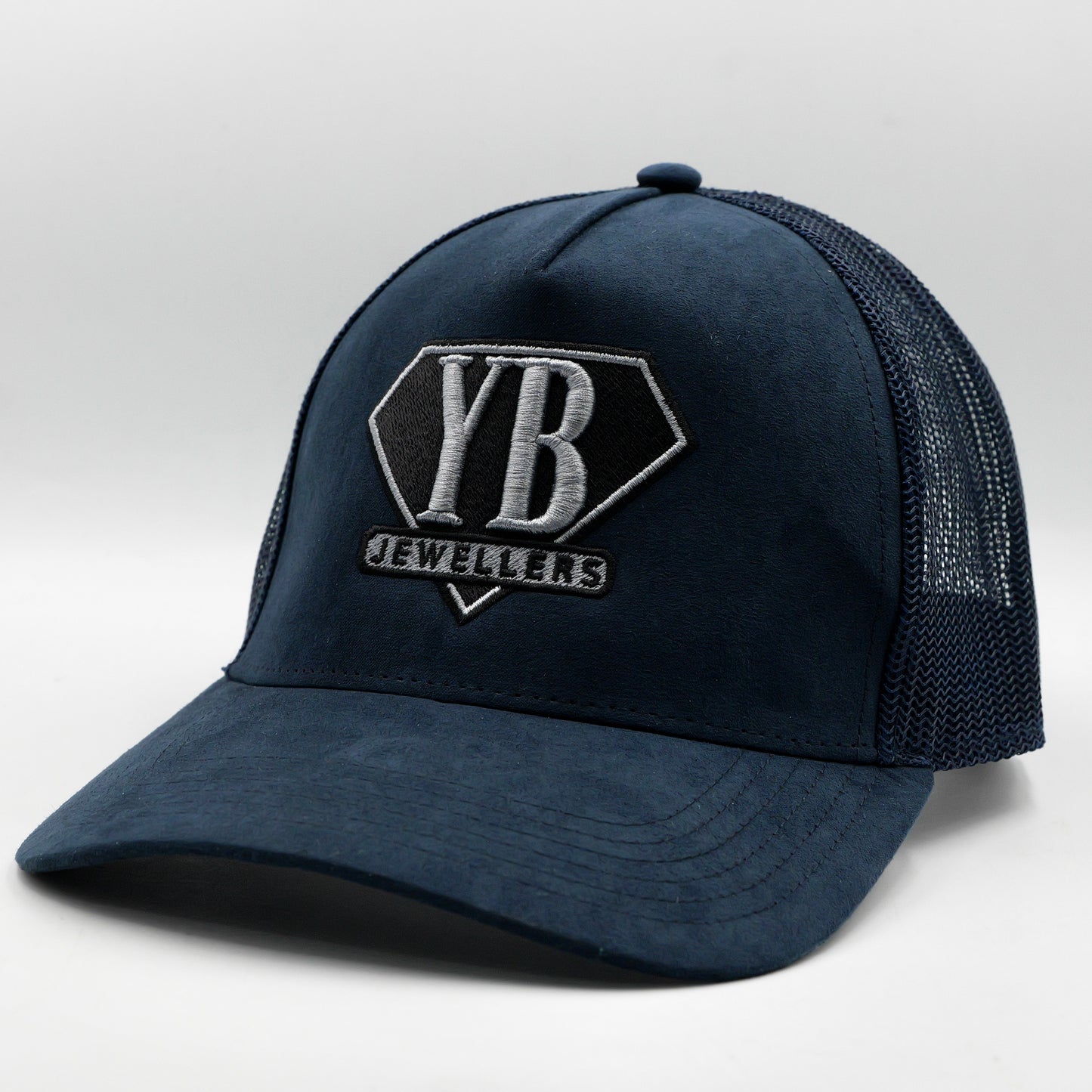 Navy blue trucker cap with 'YB Jewelers' logo on a white background