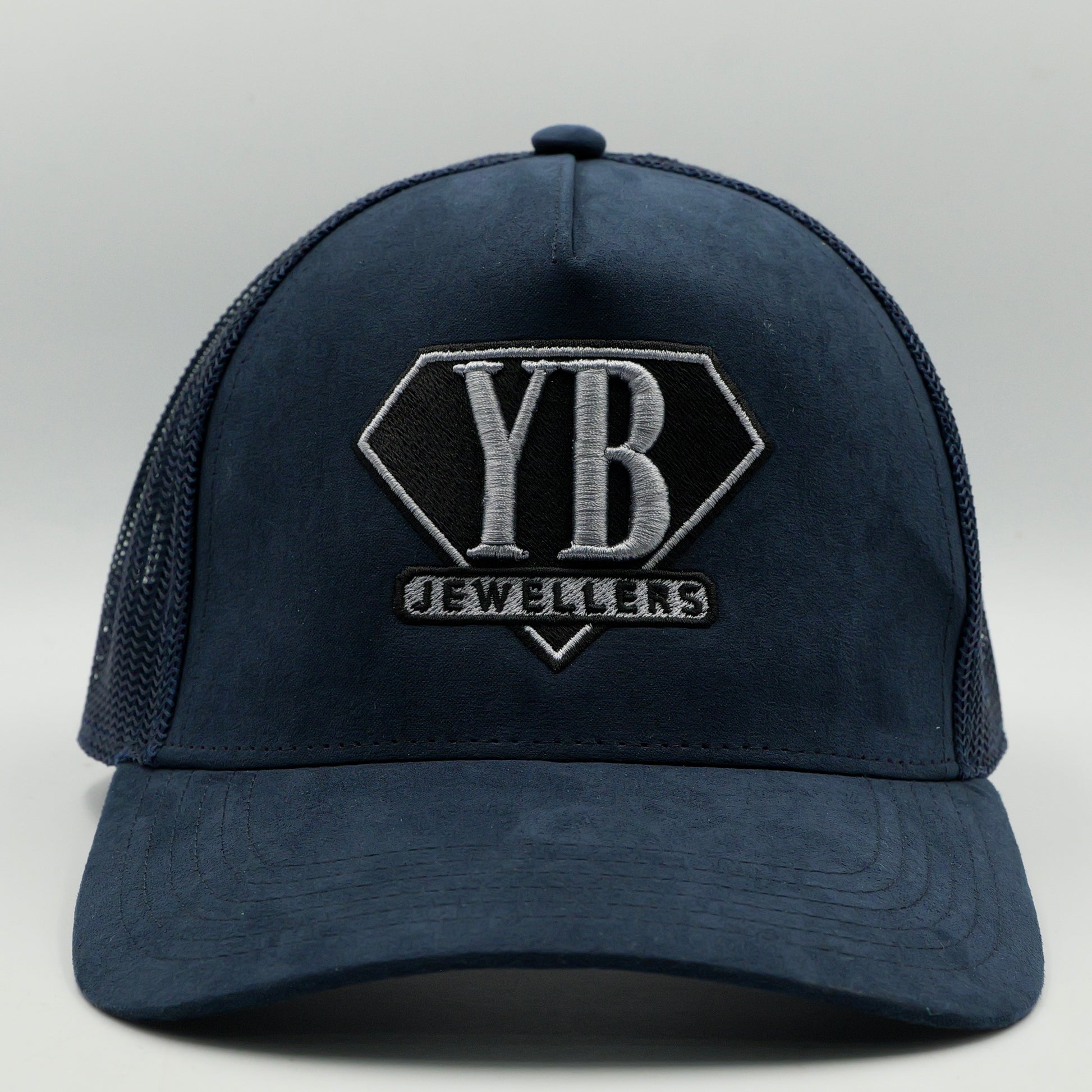 Navy blue cap with 'YB Jewellers' logo on a light gray background