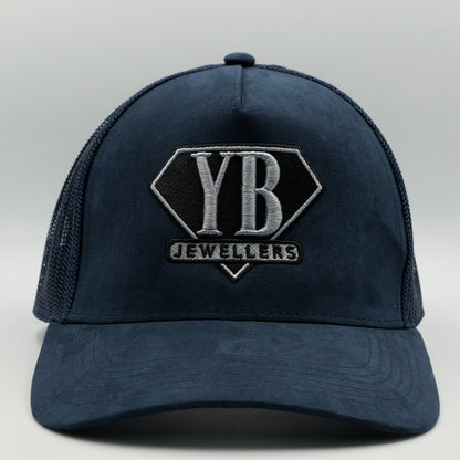 Navy blue cap with 'YB Jewellers' logo on a light gray background
