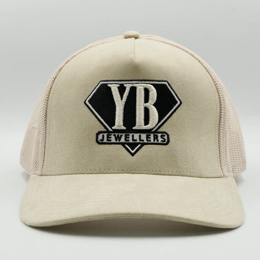 Beige cap with YB Jewellers logo on a gray background