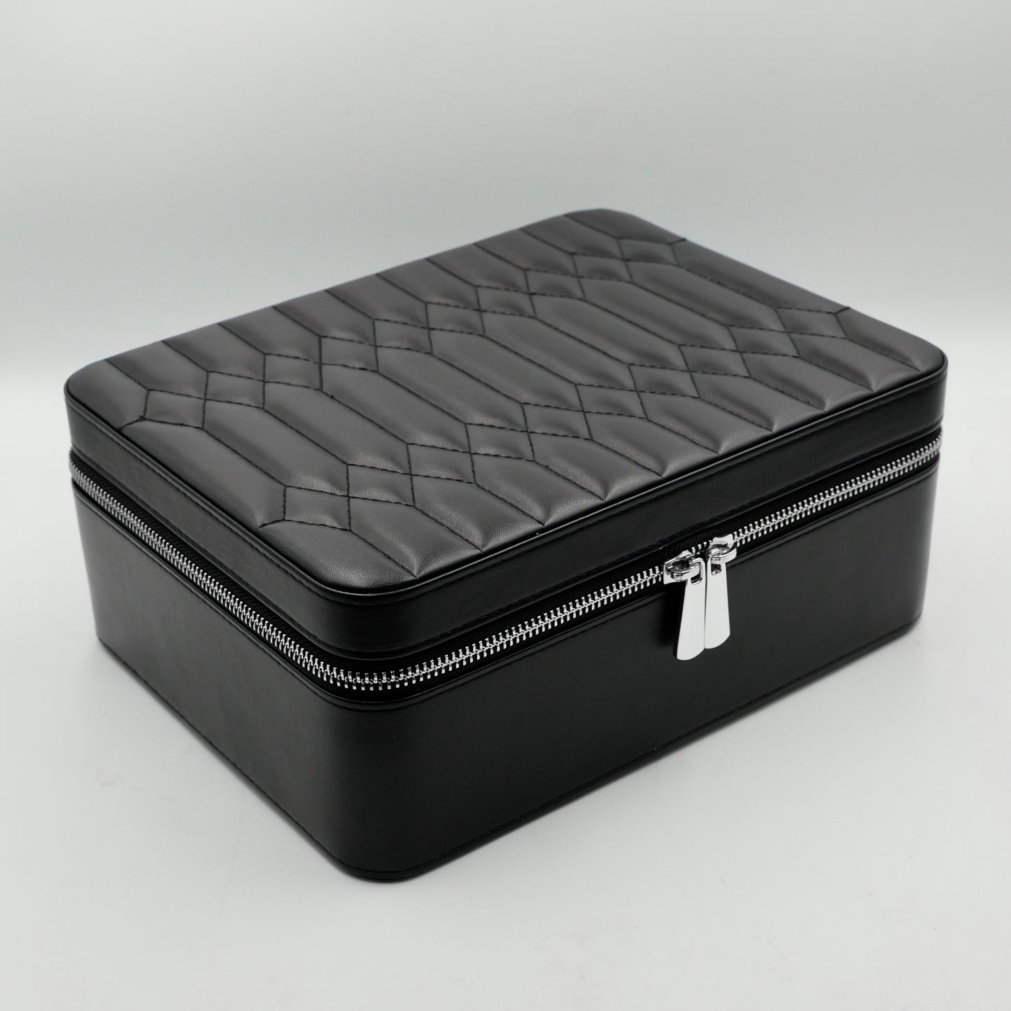 Black jewelry box with quilted lid on a gray background