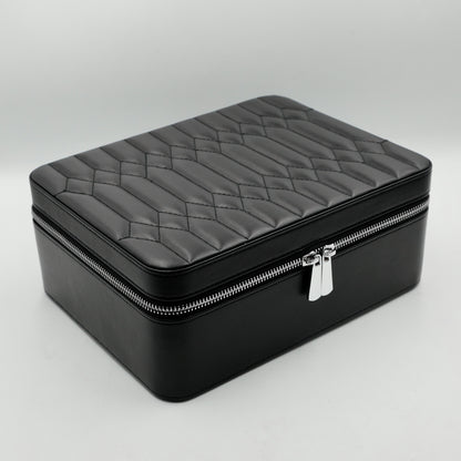 Black jewelry box with quilted lid on a gray background
