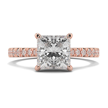 Rose gold ring with a large diamond and smaller diamonds on the band against a white background Yb jewellers engagement ring straight band princess diamond