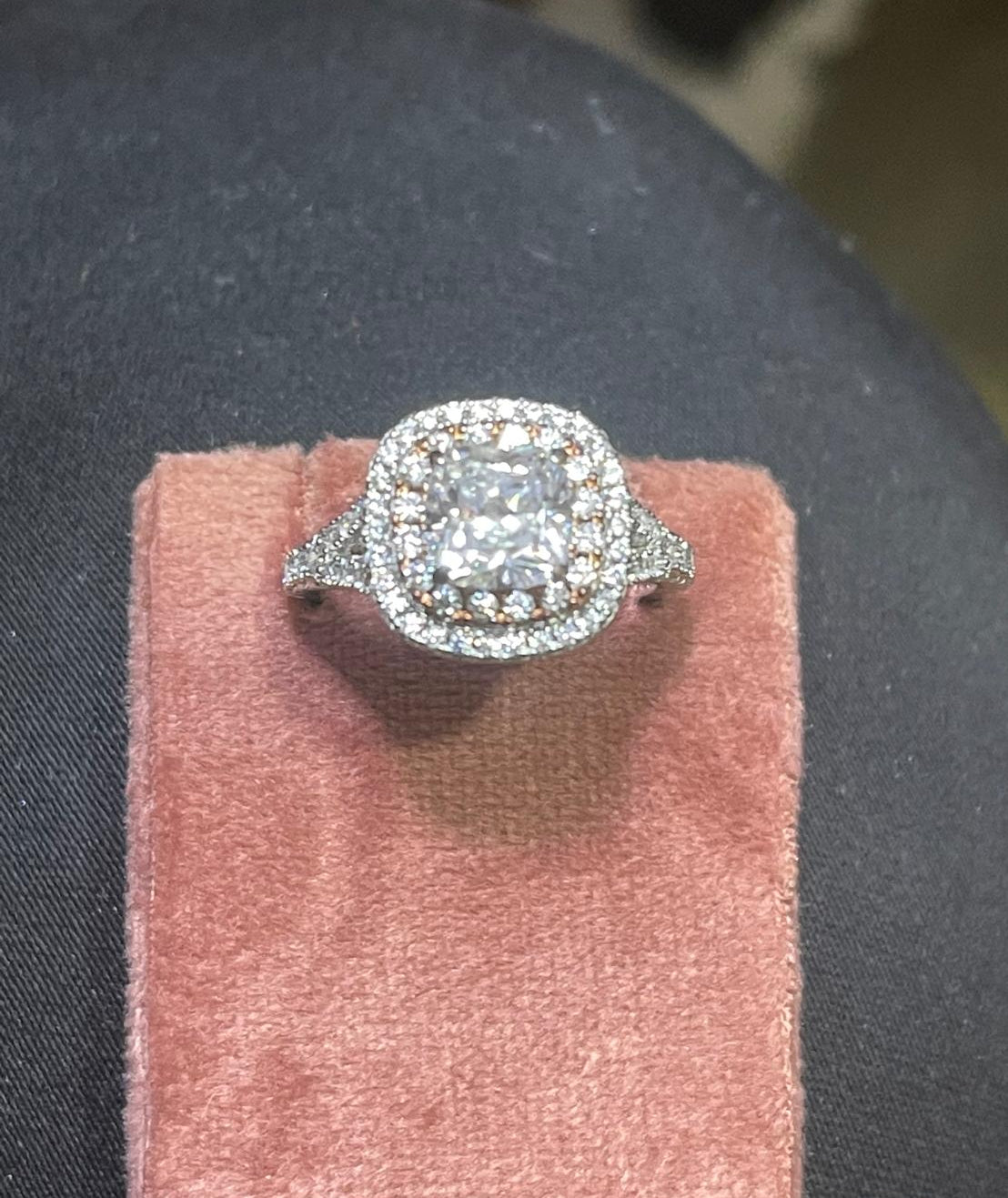 Diamond ring on a pink stand with a blurred background