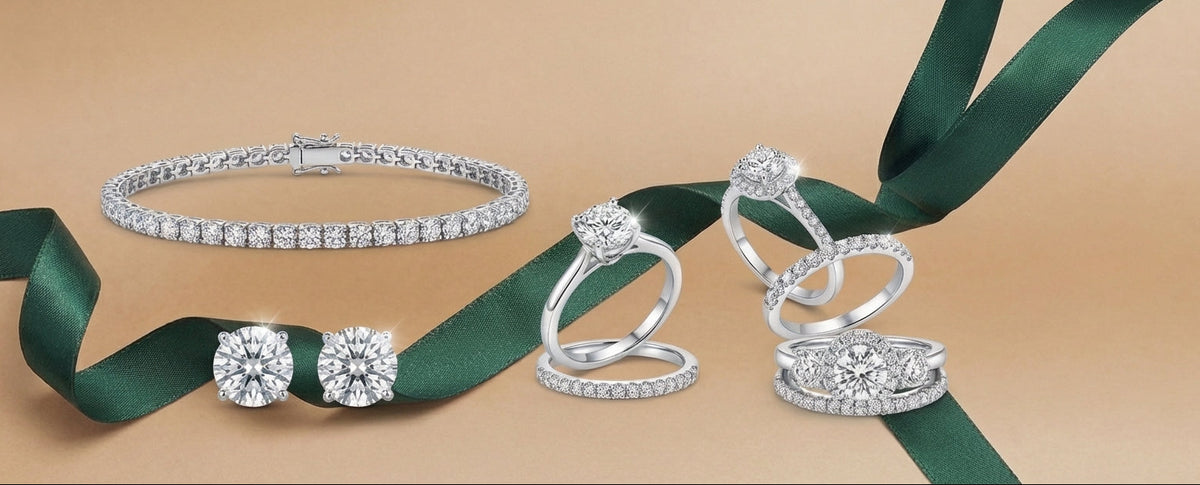 Silver jewelry set with rings and a bracelet on a green ribbon against a beige background