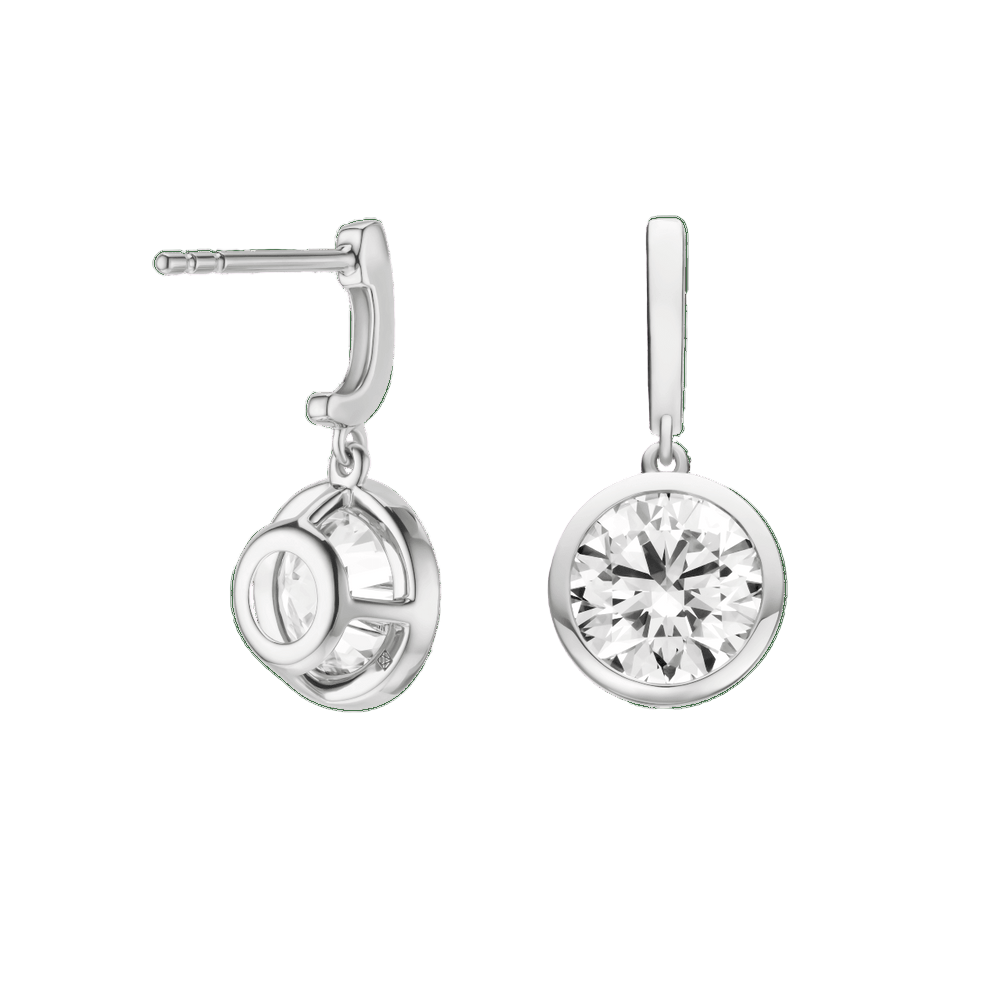 Silver earrings with clear gemstones on a green background